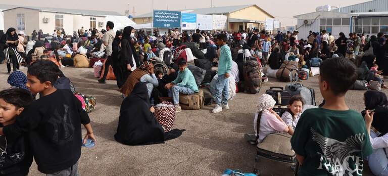 Afghans who have been deported from Iran gather at the Islam Qala border crossing in western Afghanistan.